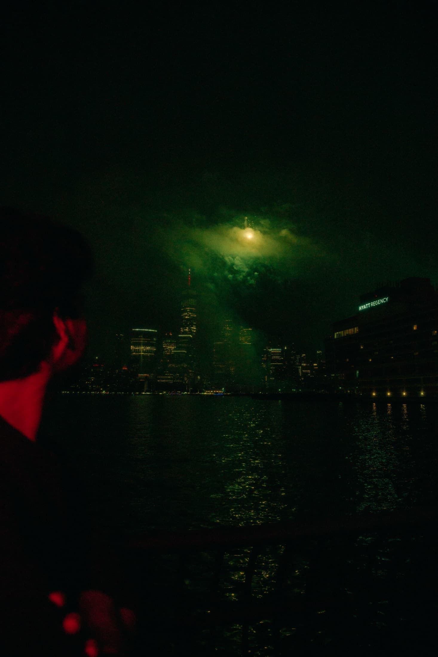 A green haze hanging above a dark waterfront and city skyline.